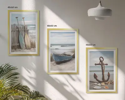 Tavelset ovanför soffa med motiv av strand, båt, ankare och sand