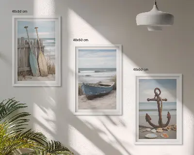 Tavelset ovanför soffa med motiv av strand, båt, ankare och sand