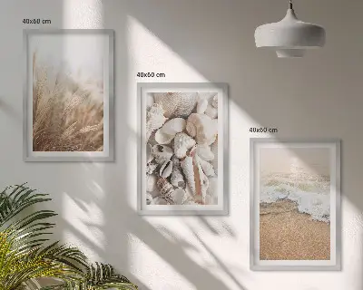 Tavelset ovanför soffa med strandmotiv, snäckor och vågor