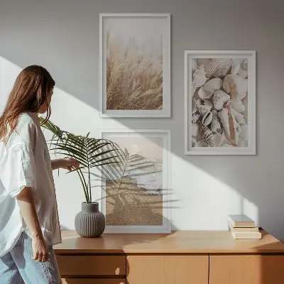 Tavelset ovanför soffa med strandmotiv, snäckor och vågor