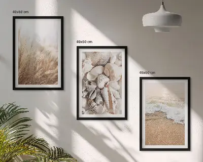 Tavelset ovanför soffa med strandmotiv, snäckor och vågor