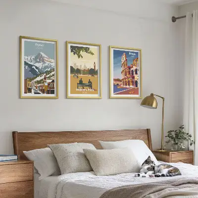 Tavelset ovanför soffa med motiv av Ouraybergen och London Coliseum