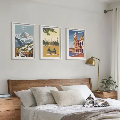 Tavelset ovanför soffa med motiv av Ouraybergen och London Coliseum
