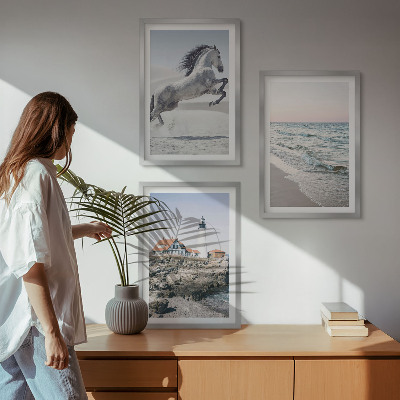 Tavelset ovanför soffa Hästar strand fyr vågor