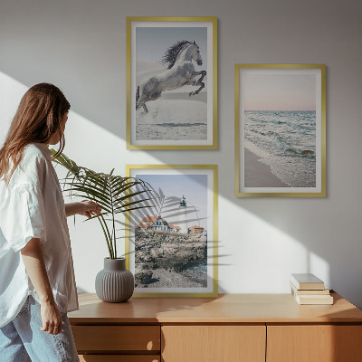 Tavelset ovanför soffa Hästar strand fyr vågor