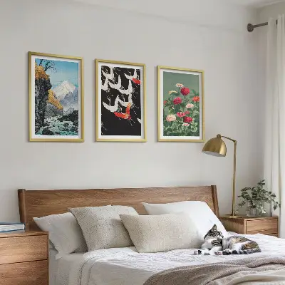 Tavelset ovanför soffan med motiv av berg, vattenfall, fåglar och blommor