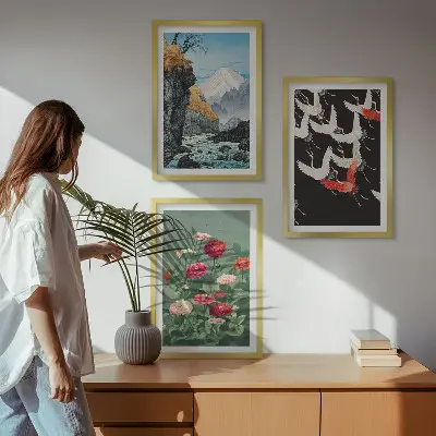 Tavelset ovanför soffan med motiv av berg, vattenfall, fåglar och blommor