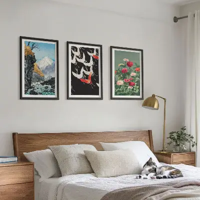 Tavelset ovanför soffan med motiv av berg, vattenfall, fåglar och blommor