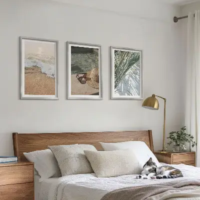 Tavelset ovanför soffa motiv med vatten, strandhatt och solglasögon