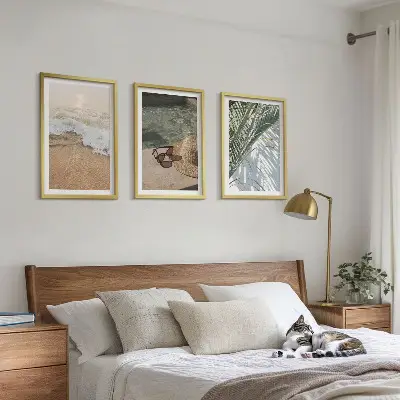 Tavelset ovanför soffa motiv med vatten, strandhatt och solglasögon