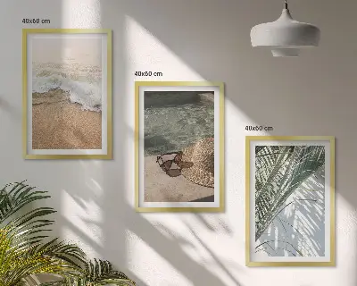 Tavelset ovanför soffa motiv med vatten, strandhatt och solglasögon