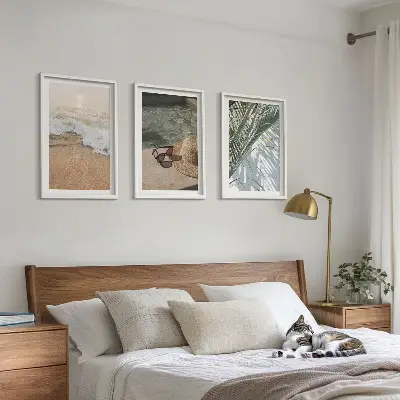 Tavelset ovanför soffa motiv med vatten, strandhatt och solglasögon