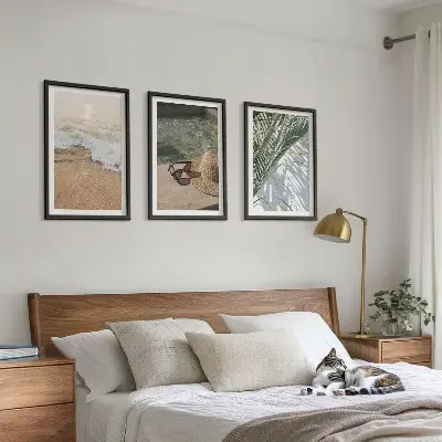 Tavelset ovanför soffa motiv med vatten, strandhatt och solglasögon