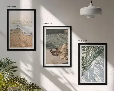 Tavelset ovanför soffa motiv med vatten, strandhatt och solglasögon