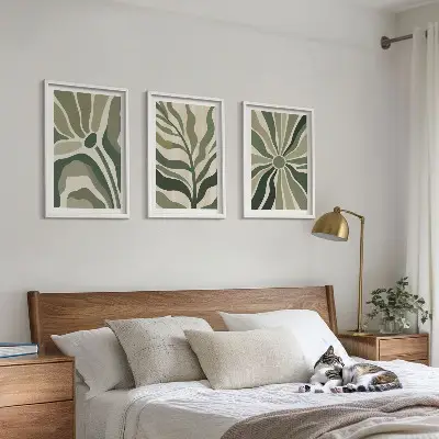 Tavelset ovanför soffa med gröna och beige växtmönster