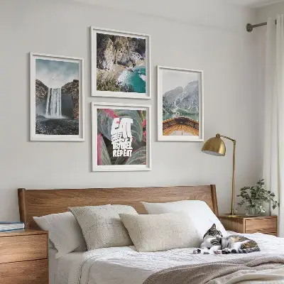 Tavelvägg ovanför soffa med motiv av vattenfall, berg och natur