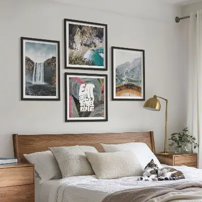 Tavelvägg ovanför soffa med motiv av vattenfall, berg och natur