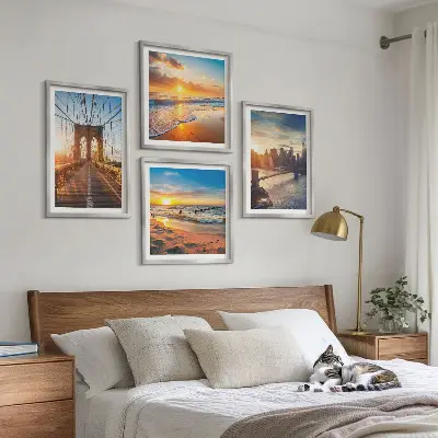 Tavelvägg ovanför soffa med motiv av broar i solnedgång över stad