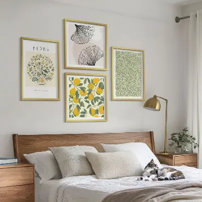 Tavelvägg ovanför soffa med motiv av citronörter och blad