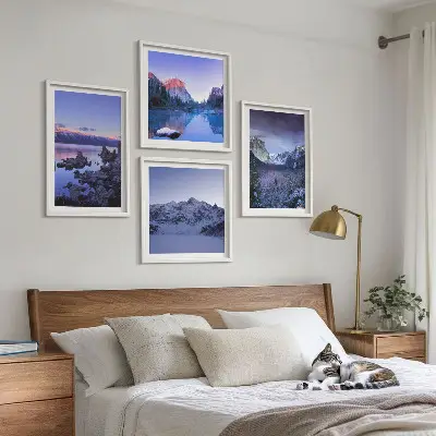 Tavelvägg ovanför soffa bergslandskap med solnedgång vid vatten