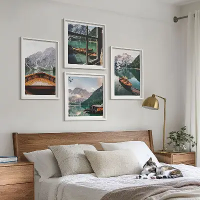 Tavelvägg med 4 tavlor med motiv av sjö, berg, båtar, stuga och fönster