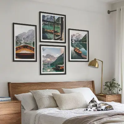 Tavelvägg med 4 tavlor med motiv av sjö, berg, båtar, stuga och fönster