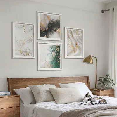 Tavelvägg ovanför soffa med abstrakta mönster i vitt svart och grönt