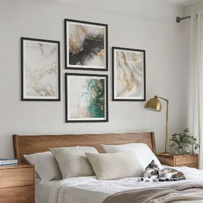 Tavelvägg ovanför soffa med abstrakta mönster i vitt svart och grönt