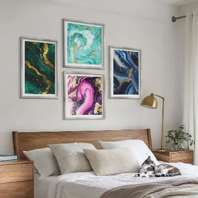 Tavelvägg ovanför soffa med abstrakta mönster i rosa grönt och blått
