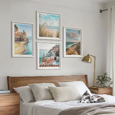 Tavelvägg med 4 tavlor med motiv av landskap med strand, stad och klippor