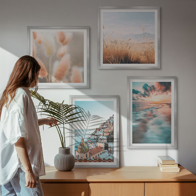 Tavelvägg ovanför soffa Havssolnedgång hus blommor