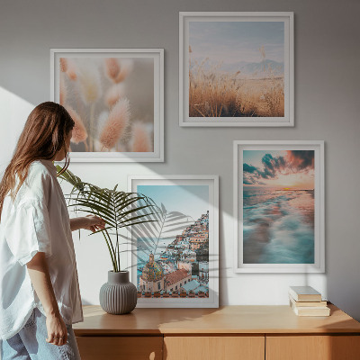 Tavelvägg ovanför soffa Havssolnedgång hus blommor