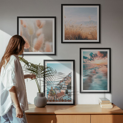 Tavelvägg ovanför soffa Havssolnedgång hus blommor
