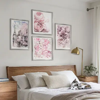 Tavelvägg ovanför soffa med romantiskt landskap av rosa blommor