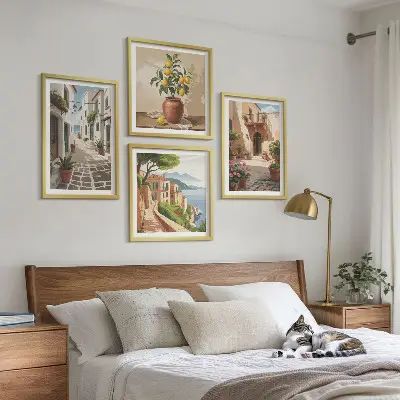 Tavelvägg ovanför soffa med motiv av gator, hus, växter och krukor