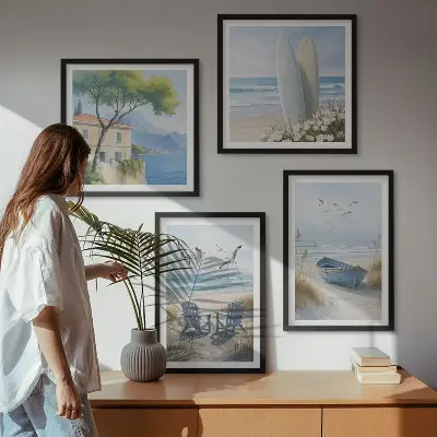Tavelvägg ovanför soffa med motiv av strandbrädor, surfbåt och fåglar