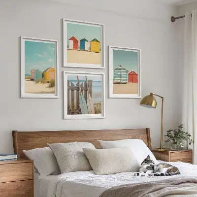 Tavelvägg ovanför soffa färgglada hus, strand och sol