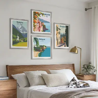 Tavelvägg ovanför soffa med motiv av bergslandskap och städer