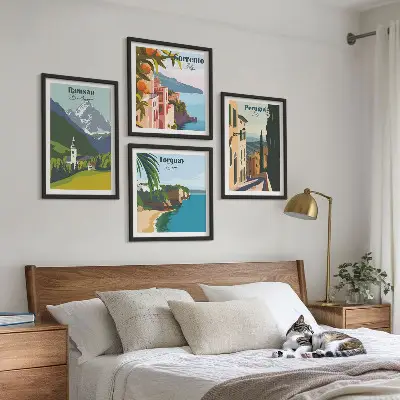 Tavelvägg ovanför soffa med motiv av bergslandskap och städer