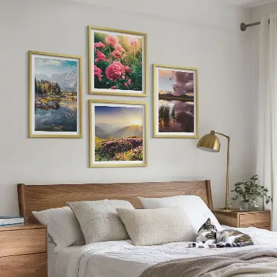 Tavelvägg ovanför soffa med motiv av blommor, trädgård, berg, äng och vatten