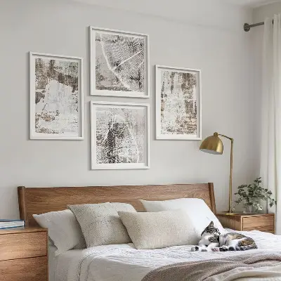 Tavelvägg ovanför soffa med abstrakta mönster i vitt och brunt