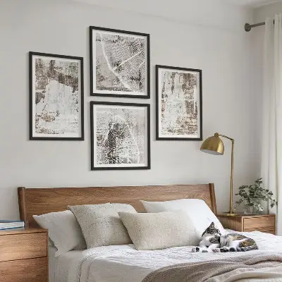 Tavelvägg ovanför soffa med abstrakta mönster i vitt och brunt