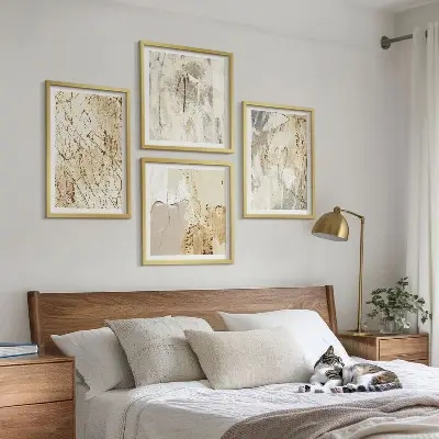Tavelvägg ovanför soffa med beige abstrakta former och linjer