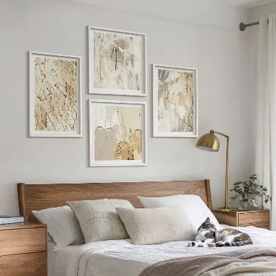 Tavelvägg ovanför soffa med beige abstrakta former och linjer