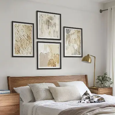 Tavelvägg ovanför soffa med beige abstrakta former och linjer