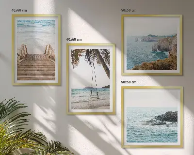 Tavelvägg ovanför soffa med motiv av trappor vid havet och en gunga