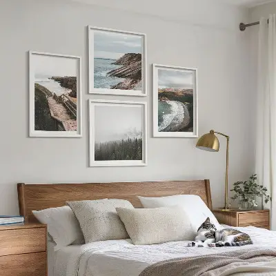Tavelvägg ovanför soffa med klipputsikt och strandlandskap