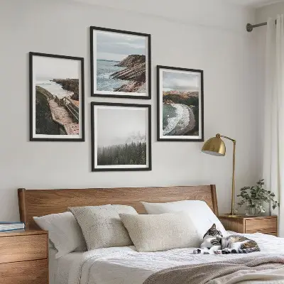 Tavelvägg ovanför soffa med klipputsikt och strandlandskap