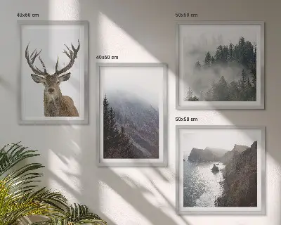 Tavelvägg ovanför soffan med motiv av bergslandskap med dimma och rådjur