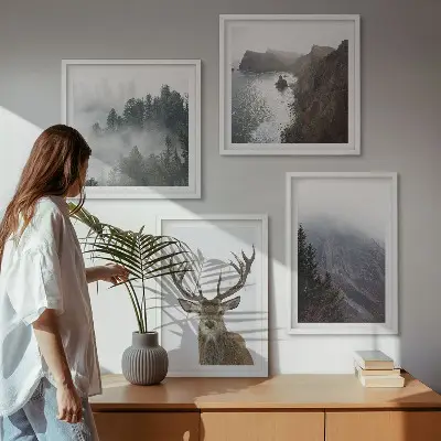 Tavelvägg ovanför soffan med motiv av bergslandskap med dimma och rådjur